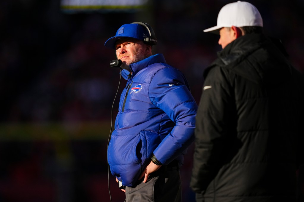 Buffalo Bills head coach Sean McDermott in a blue coat, hat, and headset looks on from the sideline.