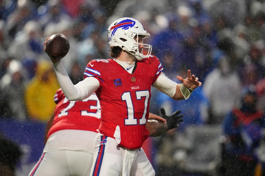 Buffalo Bills' Josh Allen throws the football during a game in the snow.