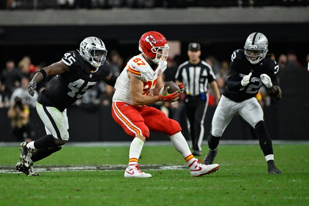 Kansas City Chiefs tight end Travis Kelce (87) catches a pass as Las Vegas Raiders linebacker Devin White (45) and safety Lonnie Johnson Jr. (32) defend during the second half of an NFL football game Sunday, January 4, 2026, in Las Vegas.  
