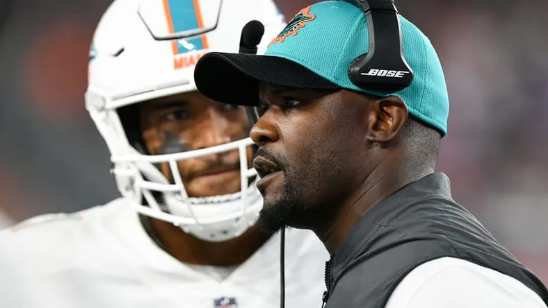 Miami Dolphins head coach Brian Flores talks with quarterback Tua Tagovailoa during a timeout against the New England Patriots.