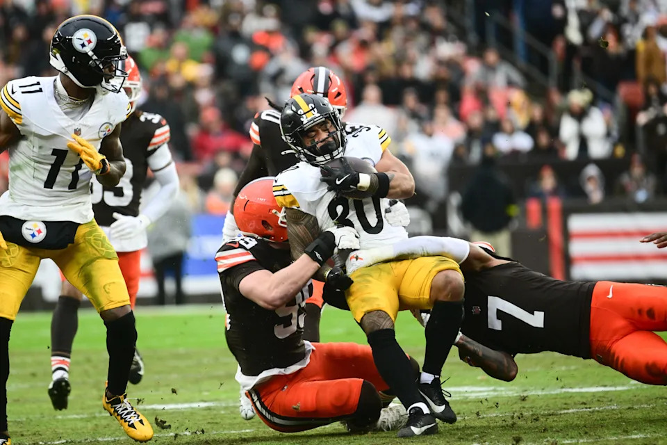 Dec 28, 2025; Cleveland, Ohio, USA; Pittsburgh Steelers running back Jaylen Warren (30) is tackled by Cleveland Browns defensive end Cameron Thomas (99) and cornerback Tyson Campbell (7) in the first quarter at Huntington Bank Field. Mandatory Credit: Ken Blaze-Imagn Images