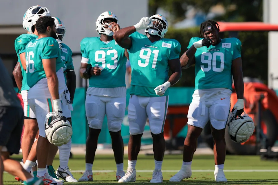 Jul 29, 2025; Miami Gardens, FL, USA; Miami Dolphins defensive tackle Zeek Biggers (93), defensive tackle Matthew Butler (91), and defensive tackle Kenneth Grant (90) hydrate during training camp at Baptist Health Training Complex. Mandatory Credit: Sam Navarro-Imagn Images