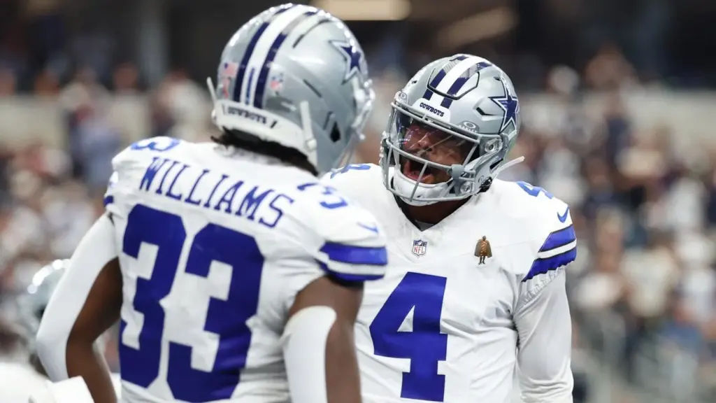 Dallas Cowboys football players celebrating on the field during a game, wearing team uniforms and helmets, in an exciting moment of the NFL season.