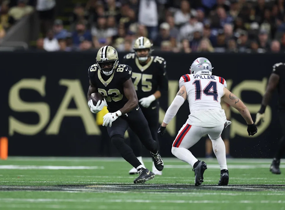 New Orleans Saints tight end Juwan Johnson (83) runs for a gain past New England Patriots linebacker Robert Spillane (14) during the second half at Caesars Superdome. Stephen Lew-Imagn Images