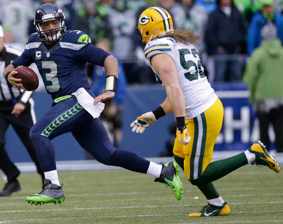 Seattle Seahawks quarterback Russell Wilson runs for four yards before before run down by Green Bay Packers outside linebacker Clay Matthews.