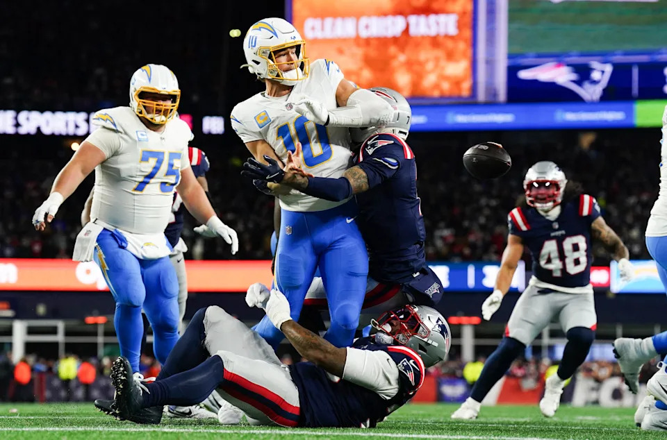Jan 11, 2026; Foxborough, MA, USA; Los Angeles Chargers quarterback Justin Herbert (10) throws the ball away to avoid a sack during the second quarter against the New England Patriots in an AFC Wild Card Round game at Gillette Stadium. Mandatory Credit: David Butler II-Imagn Images