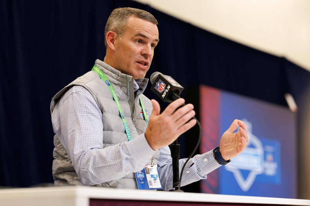 Brandon Beane speaking at a podium with an NFL microphone.