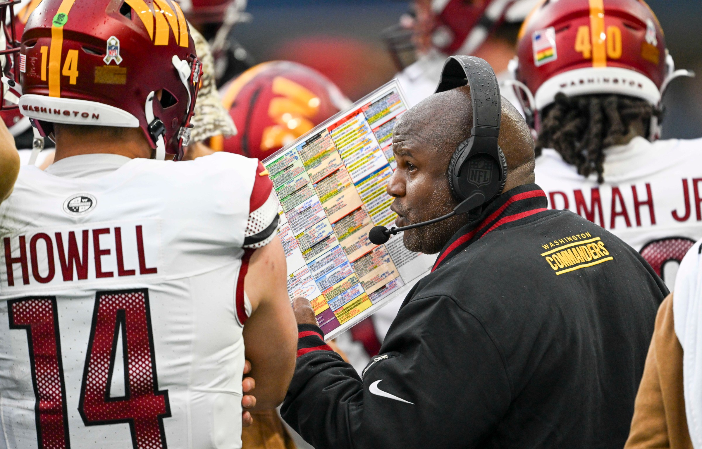 SEATTLE, WA -NOVEMBER 12: Washington Commanders offensive coordinator Eric Bieniemy talks with quarterback Sam Howell (14) during a timeout against the Seattle Seahawks at Lumen Field on November 12, 2023. (Photo by Jonathan Newton/The Washington Post via Getty Images)