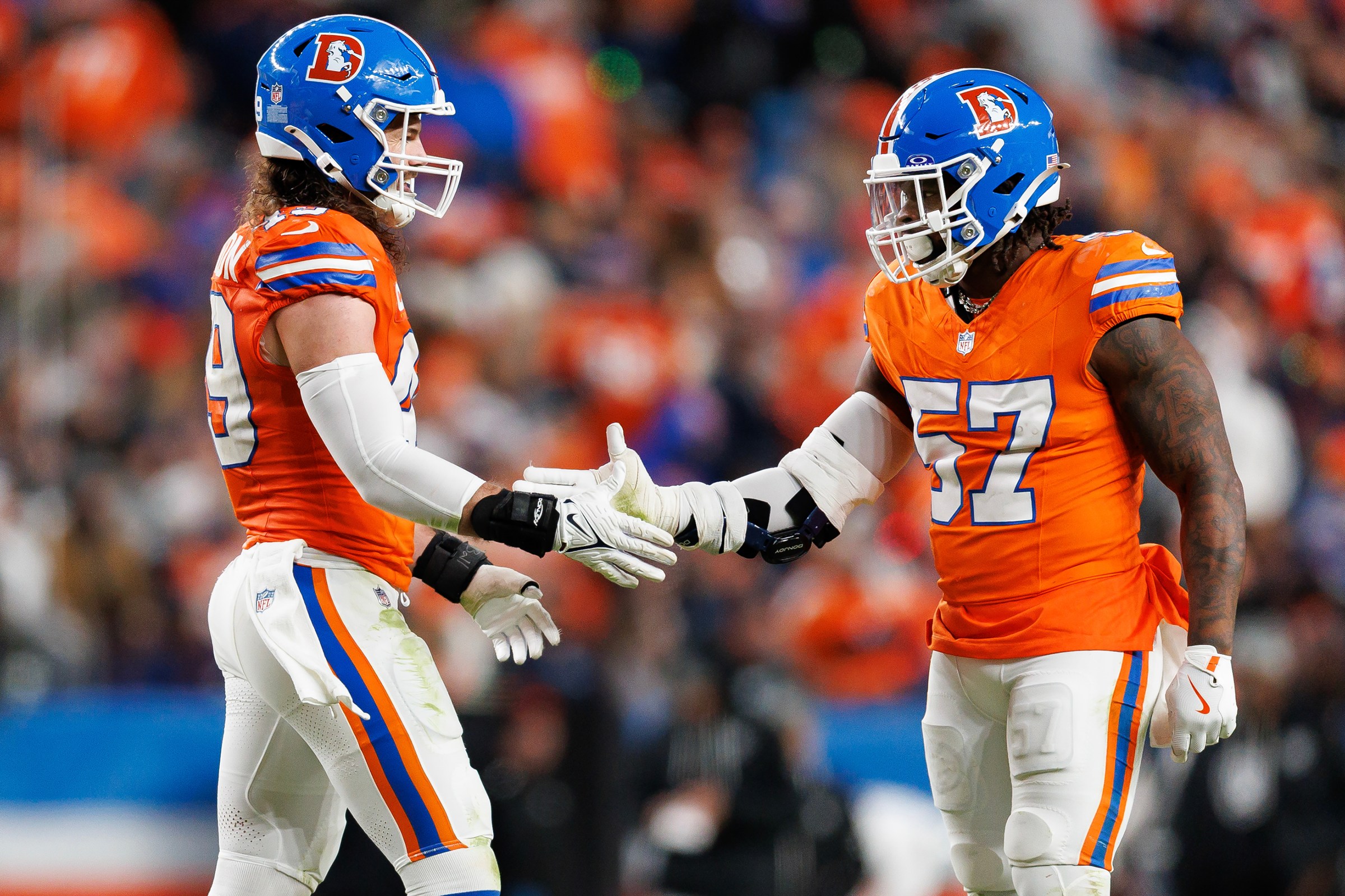 DENVER, COLORADO - NOVEMBER 6: Alex Singleton #49 of the Denver Broncos interacts with Dre Greenlaw #57 during the second half of an NFL football game against the Las Vegas Raiders at Empower Field At Mile High on November 06, 2025 in Denver, Colorado. (Photo by Brooke Sutton/Getty Images)