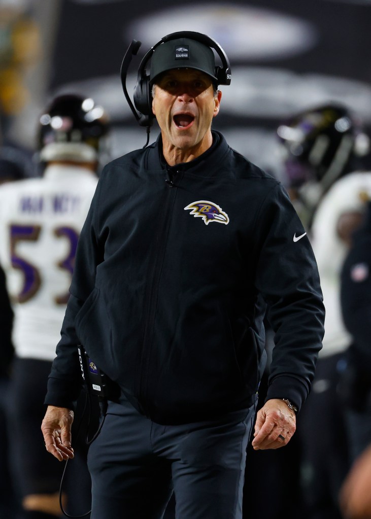 Head coach John Harbaugh of the Baltimore Ravens yelling in excitement while wearing a headset.