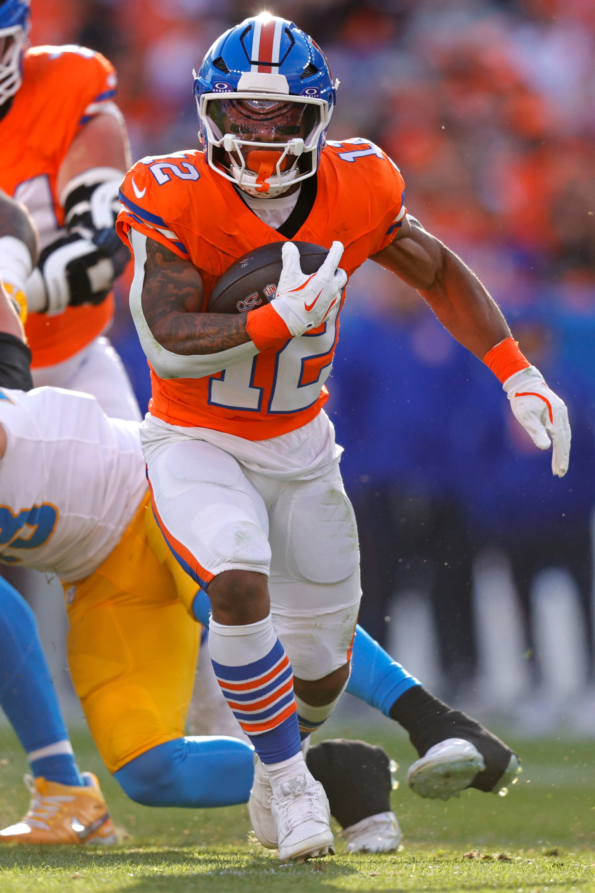 Jan 4, 2026; Denver, Colorado, USA; Denver Broncos running back RJ Harvey (12) runs with the ball against the Los Angeles Chargers during the first half at Empower Field at Mile High. Mandatory Credit: Isaiah J. Downing-Imagn Images