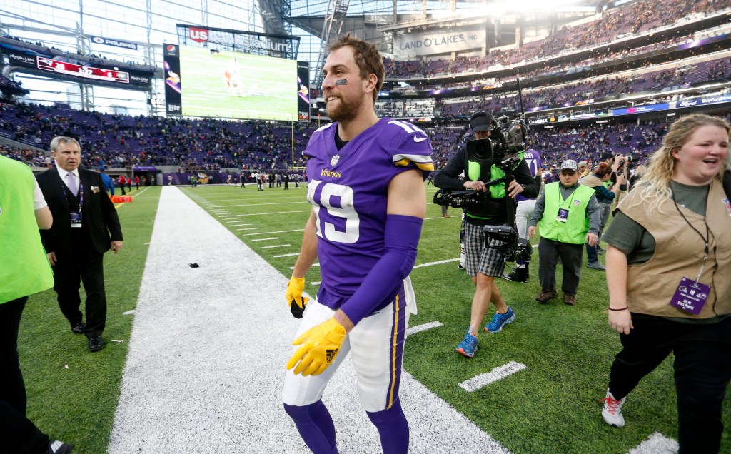 Adam Thielen, wearing a purple Minnesota Vikings jersey, walks off the field after a football game.