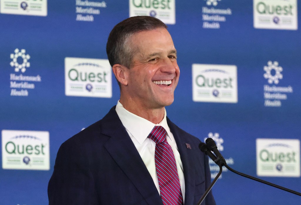 New New York Giants head coach John Harbaugh smiling during his introduction at a press conference.