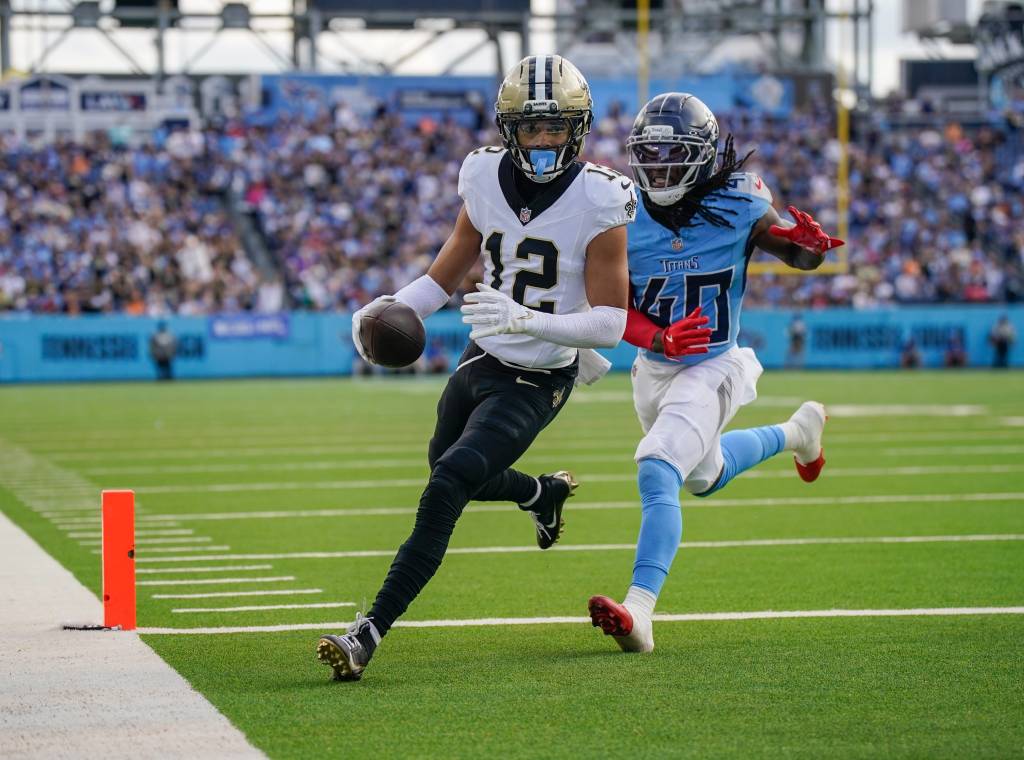 New Orleans Saints wide receiver Chris Olave (12) runs a touchdown in front of Tennessee Titans cornerback Kemon Hall (40)