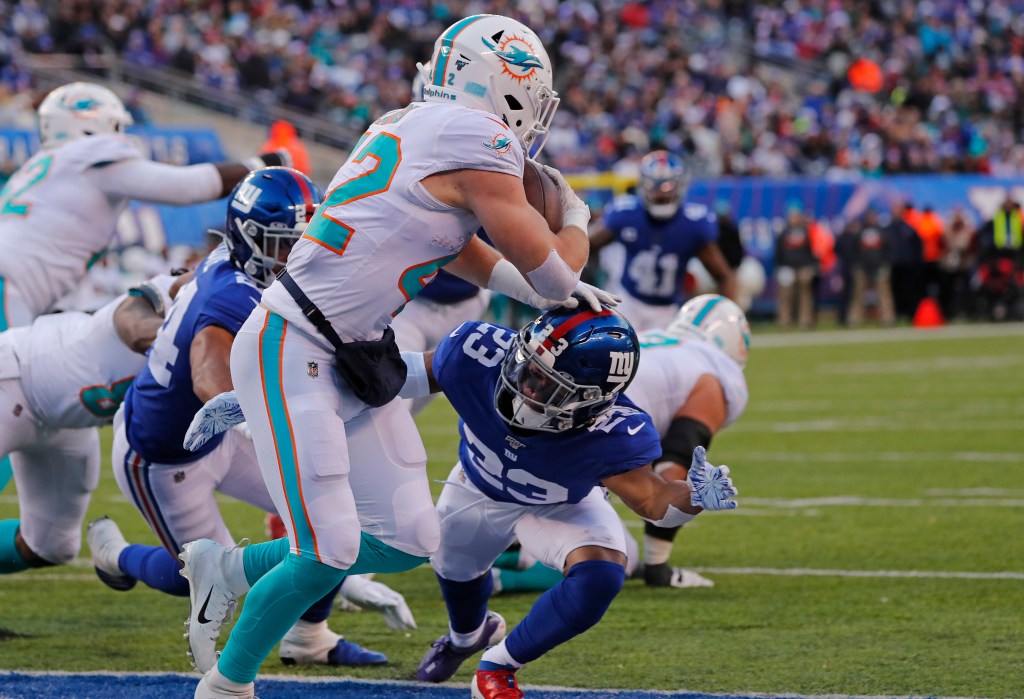 New York Giants defensive back Sam Beal #23 tackling Miami Dolphins running back Patrick Laird #42 in the end zone.
