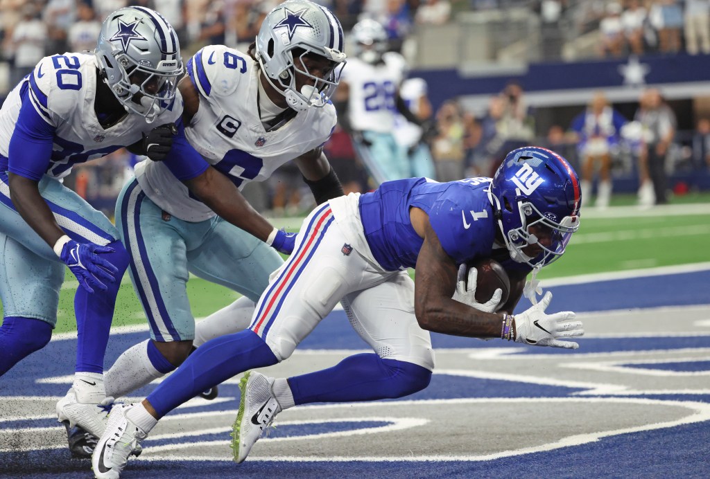 New York Giants wide receiver Malik Nabers #1 catching a touchdown pass, guarded by Dallas Cowboys safety Donovan Wilson #6 and Dallas Cowboys cornerback Kaiir Elam #20.