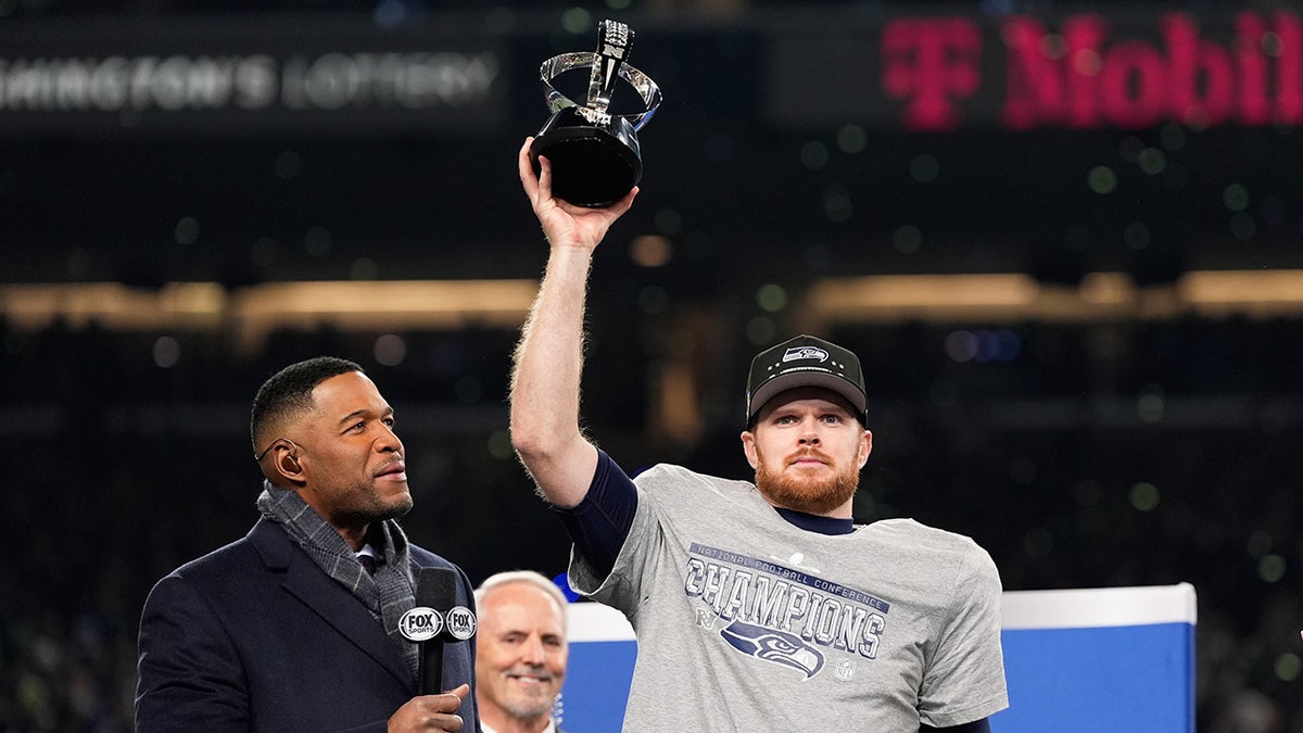 Sam Darnold raises the Halas Trophy