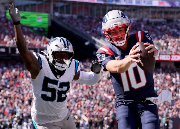 New England Patriots quarterback Drake Maye scores despite defended by Carolina Panthers' DJ Johnson during the second quarter of a game at Gillette Stadium. (Nancy Lane/Boston Herald)