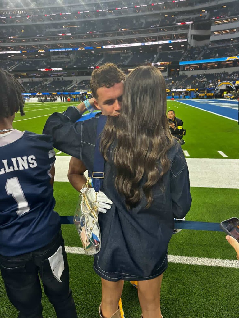 Sydney and Ladd McConkey embracing on a football field.