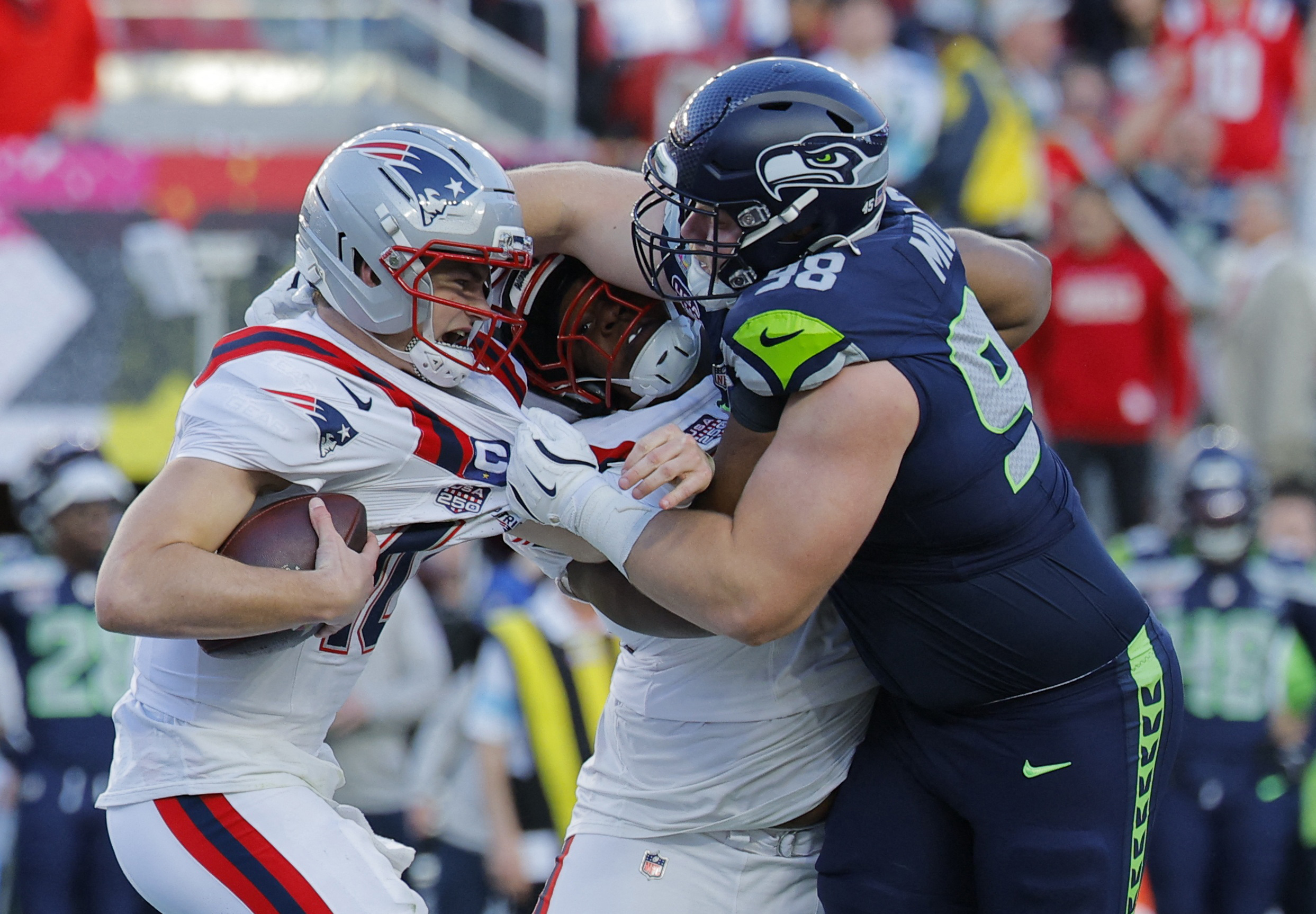 Drake Maye in action with the Seahawks’ Rylie Mills