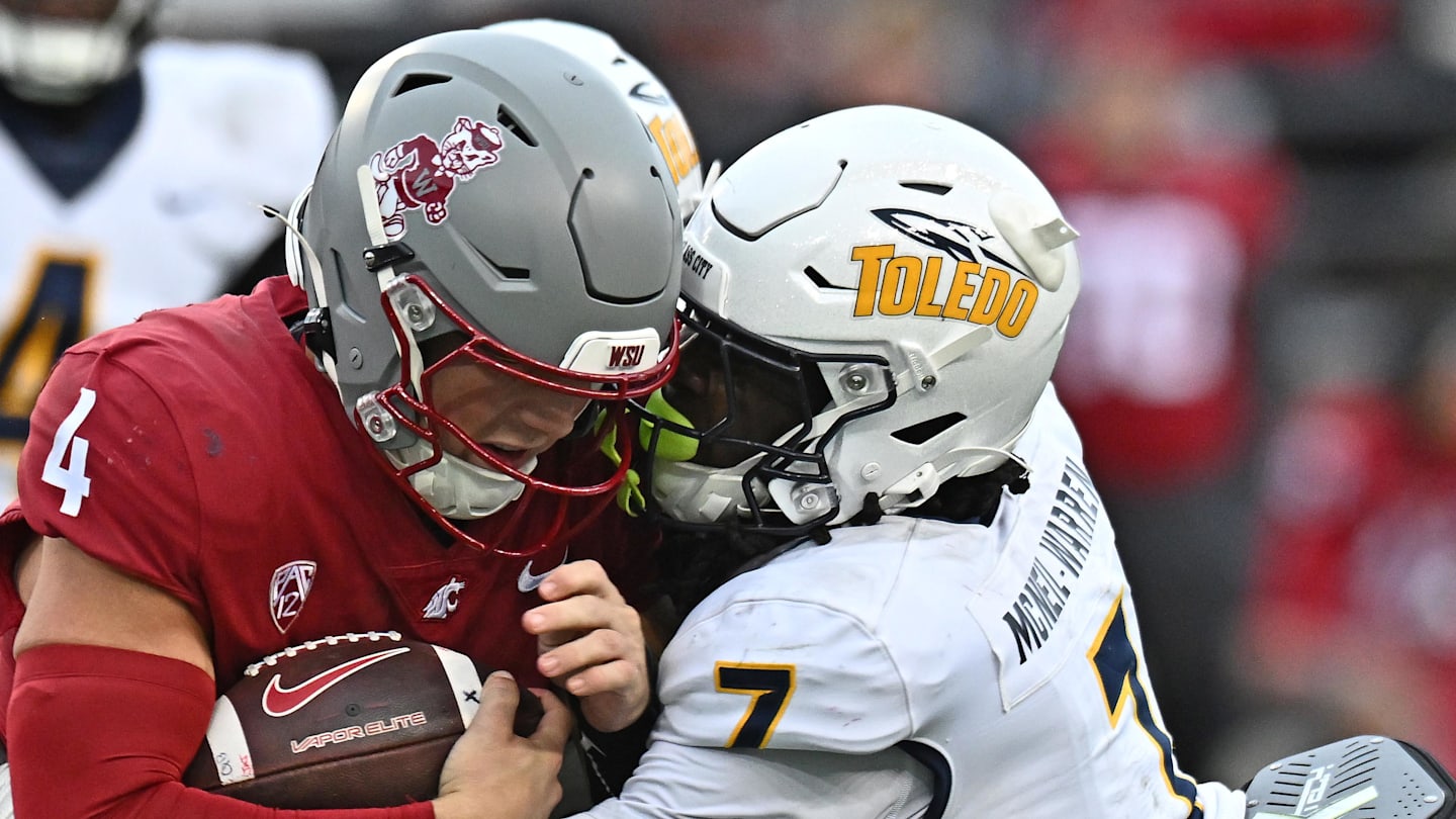 Oct 25, 2025; Pullman, Washington, USA; Washington State Cougars quarterback Zevi Eckhaus (4) is tackled by Toledo Rockets safety Emmanuel McNeil-Warren (7) in the second half at Gesa Field at Martin Stadium. Mandatory Credit: James Snook-Imagn Images
