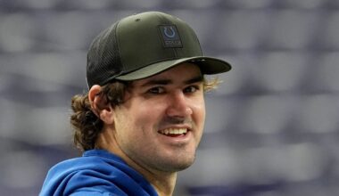 An injured Indianapolis Colts quarterback Daniel Jones talks with team staff