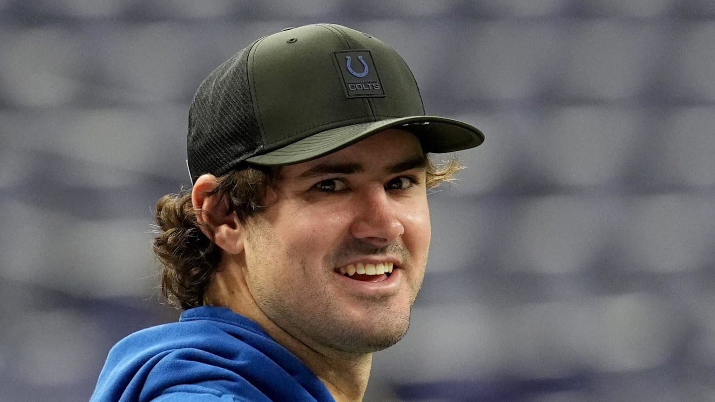 An injured Indianapolis Colts quarterback Daniel Jones talks with team staff