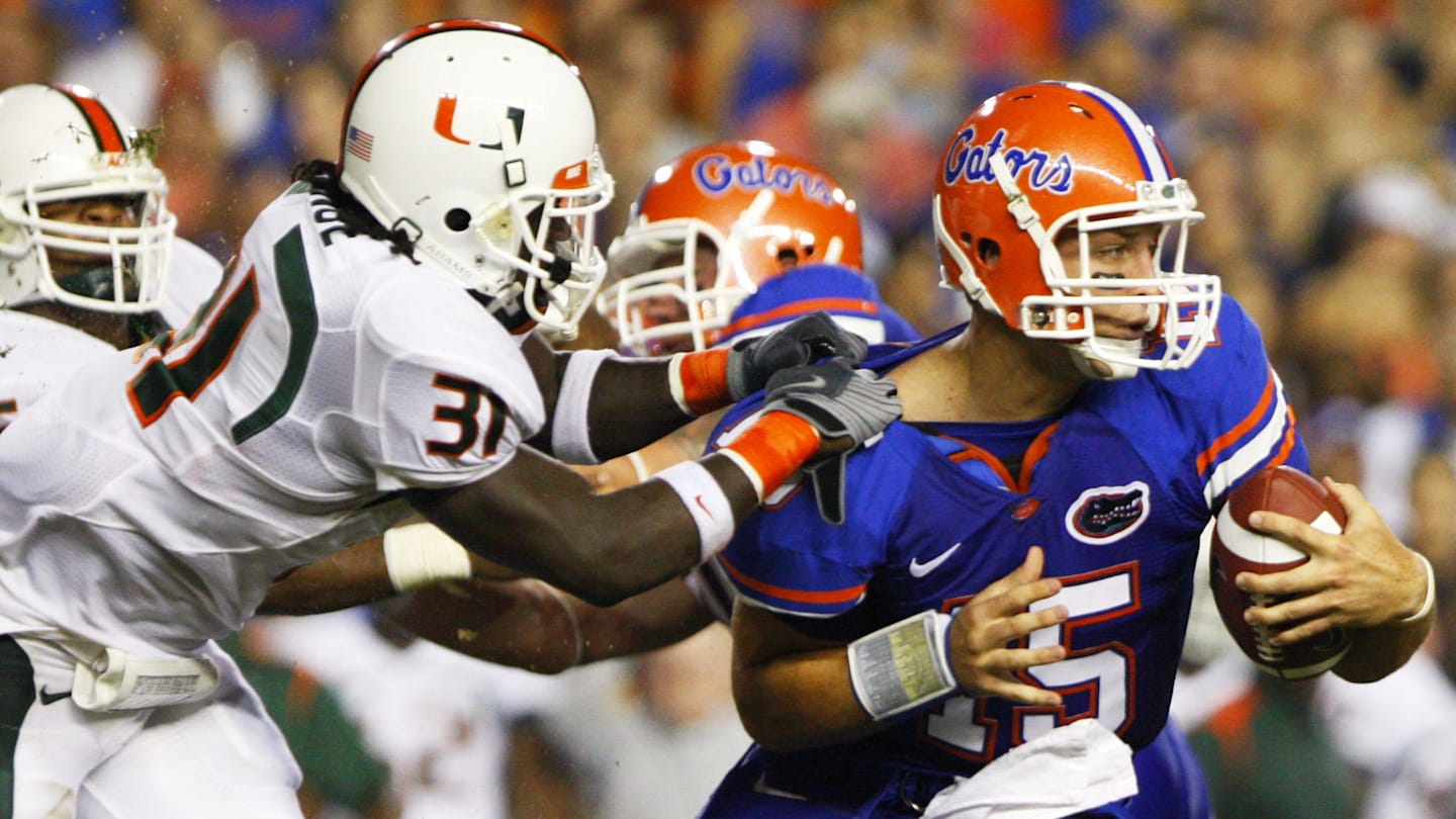 Sep 6, 2008; Gainesville, FL, USA; Florida Gators quarterback Tim Tebow (15) carries the ball as Miami Hurricanes linebacker Sean Spence (31) attempts to make the tackle in the first half at Ben Hill Griffin Stadium.  Mandatory Credit: Kim Klement-Imagn Images