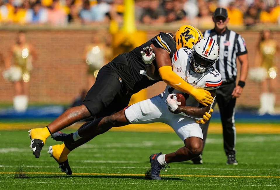 Oct 19, 2024; Columbia, Missouri, USA; Auburn Tigers tight end Rivaldo Fairweather (13) is tackled by Missouri Tigers defensive tackle Chris McClellan (7) during the first half at Faurot Field at Memorial Stadium. Mandatory Credit: Jay Biggerstaff-Imagn Images
