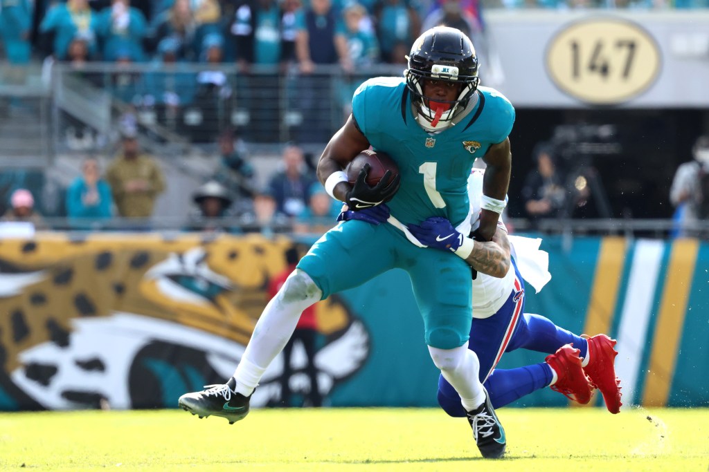 Travis Etienne Jr. of the Jacksonville Jaguars is tackled by Taron Johnson of the Buffalo Bills.