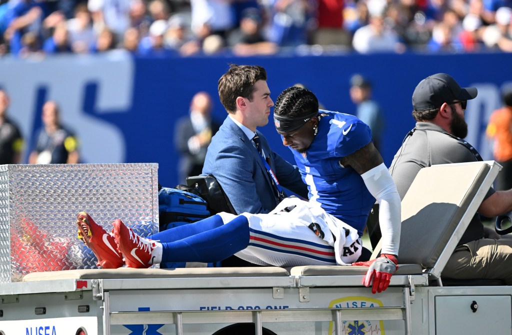 Malik Nabers #1 of the New York Giants being carted off the field after an injury during a football game.