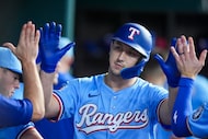 Texas Rangers left fielder Wyatt Langford celebrates in the dugout after hitting a solo home...
