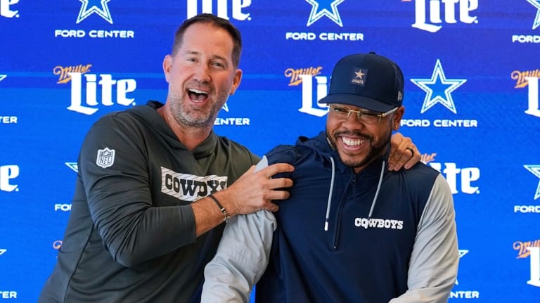Dallas Cowboys head coach Brian Schottenheimer, left, jokes with Christian...