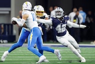 Dallas Cowboys defensive end Jadeveon Clowney (42) reaches for Los Angeles Chargers...