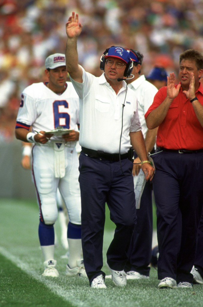 New York Giants head coach Ray Handley with his arm raised on the sidelines during a game.