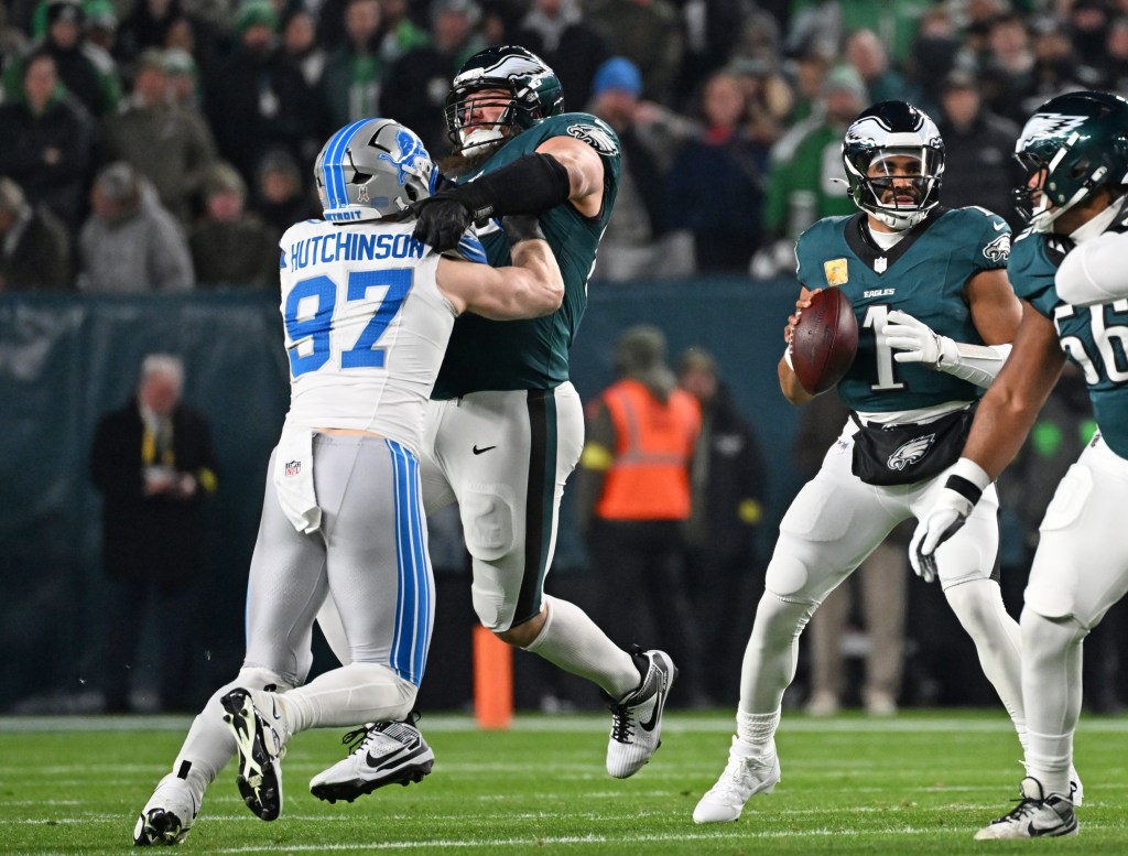 Detroit Lions defensive end Aidan Hutchinson being blocked by an Eagles offensive lineman while Jalen Hurts holds the football.