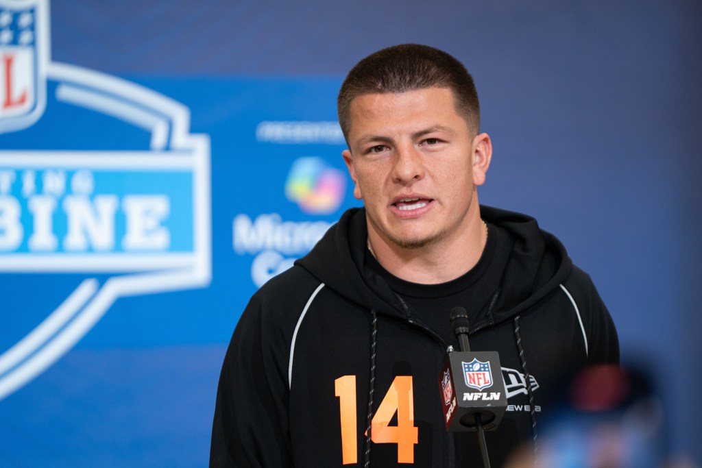 A man speaking into a microphone with "NFLN" on the mic.