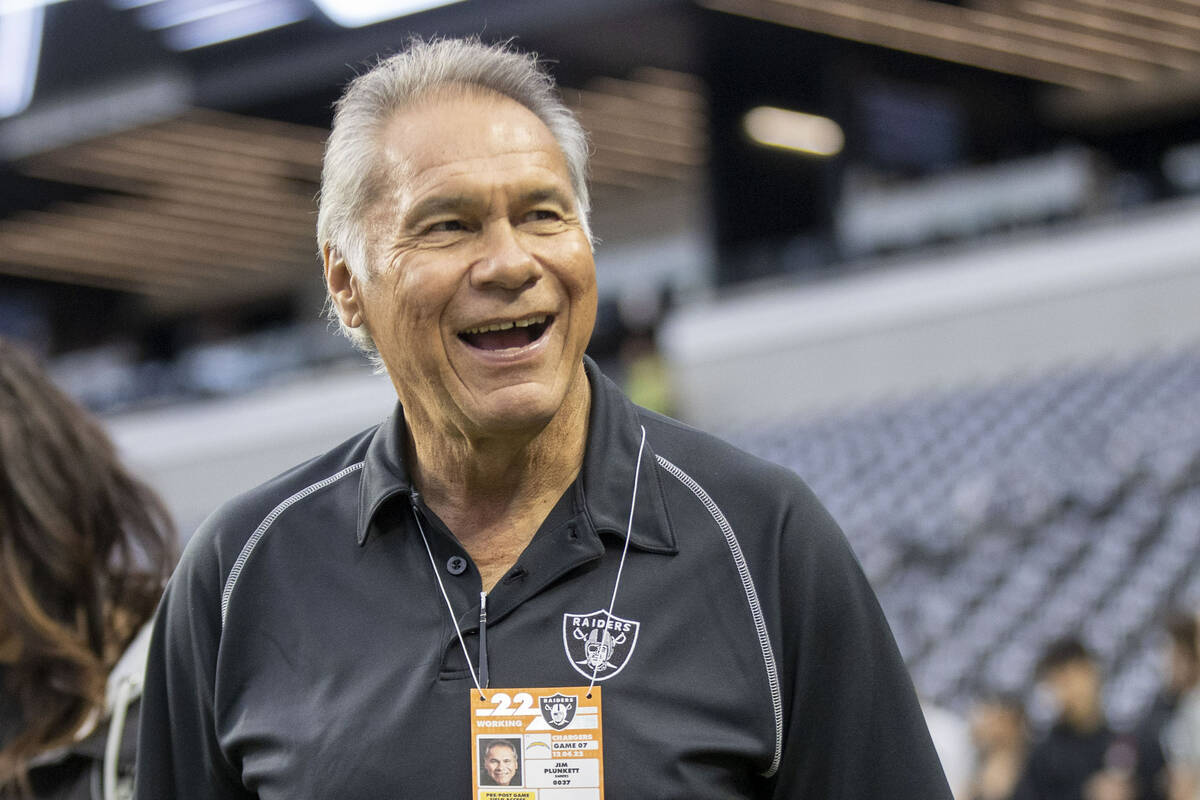 Former Raiders quarterback Jim Plunkett walks on the field before an NFL game between the Raide ...