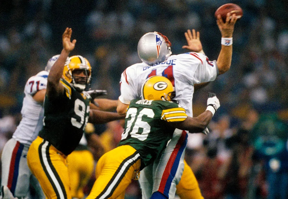 Jan 26, 1997; New Orleans, LA, USA; FILE PHOTO; Green Bay Packers defensive back Leroy Butler (36) bits New England Patriots quarterback Drew Bledsoe (11) as he releases the ball as Reggie White (92) applies pressure during Super Bowl XXXI at the Superdome. The Packers defeated the Patriots 35-21. Mandatory Credit: USA TODAY Sports