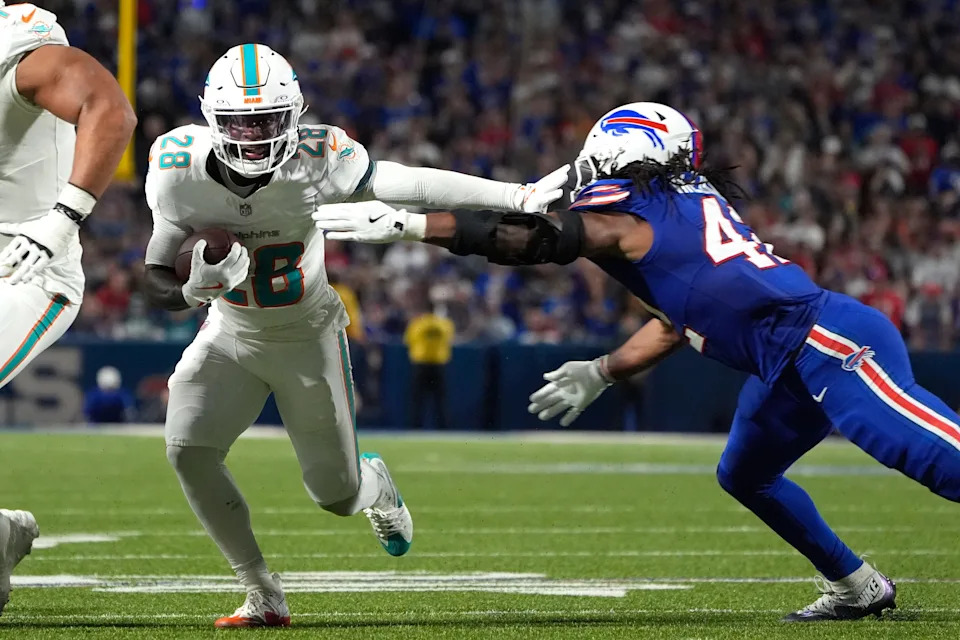 Sep 18, 2025; Orchard Park, New York, USA; Miami Dolphins running back de'von Achane (28) runs against Buffalo Bills linebacker Dorian Williams (42) in the second quarter at Highmark Stadium. Mandatory Credit: Gregory Fisher-Imagn Images