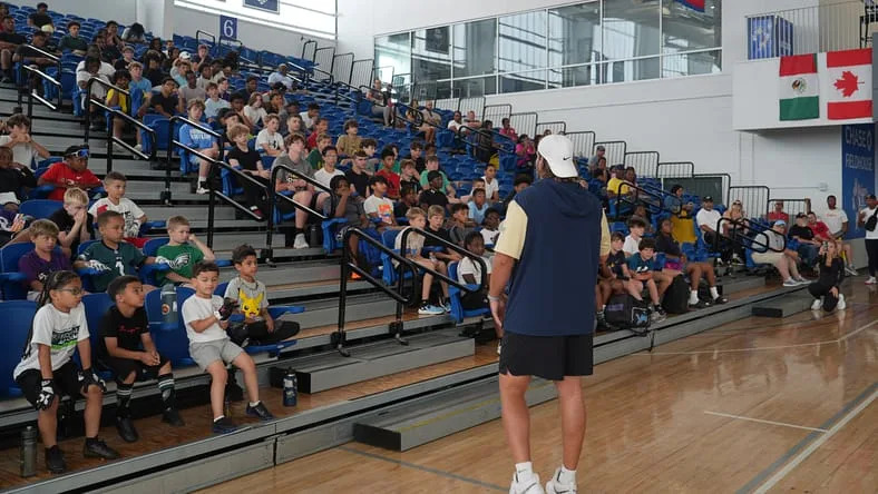 Brian O'Neill speaks to children at a community football clinic.