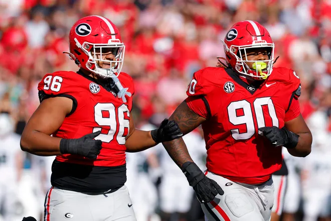 JJ Hanne #96 and Elijah Griffin #90 of the Georgia Bulldogs leave the field during the second quarter against the Charlotte 49ers