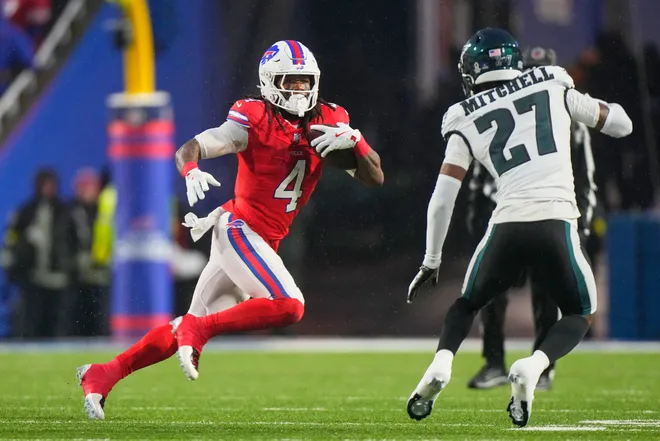 Dec 28, 2025; Orchard Park, New York, USA; Buffalo Bills running back James Cook III (4) runs the ball against Philadelphia Eagles cornerback Quinyon Mitchell (27) during the first quarter at Highmark Stadium. Mandatory Credit: Gregory Fisher-Imagn Images