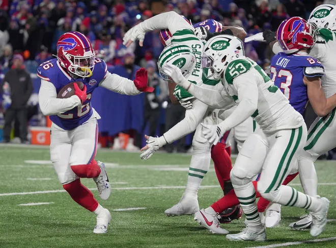 Buffalo Bills running back Ty Johnson tries to escape New York Jets defensive tackle Harrison Phillips and linebacker Mykal Walker during their home game at Highmark Stadium in Orchard Park on Jan. 4, 2026.