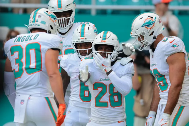 Nov 30, 2025; Miami Gardens, Florida, USA; Miami Dolphins running back De'Von Achane (28) reacts with teammates after scoring a touchdown against the New Orleans Saints during the first half at Hard Rock Stadium. Mandatory Credit: Sam Navarro-Imagn Images