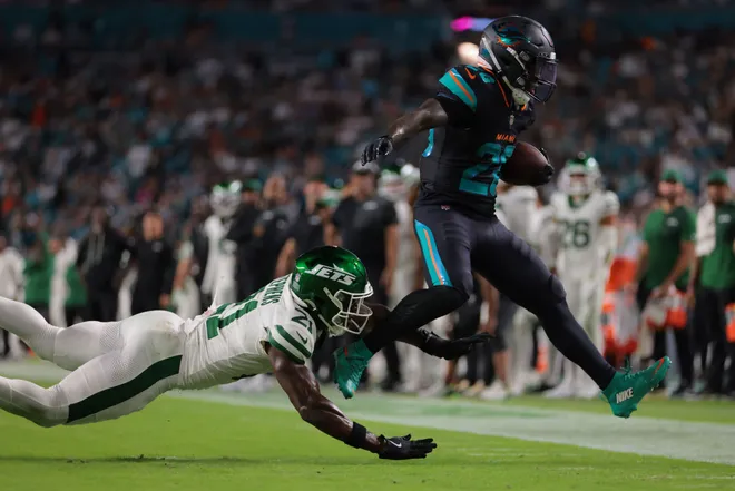 Sep 29, 2025; Miami Gardens, Florida, USA; Miami Dolphins running back De'von Achane (28) rushes the ball against New York Jets cornerback Brandon Stephens (21) during the first half at Hard Rock Stadium. Mandatory Credit: Sam Navarro-Imagn Images