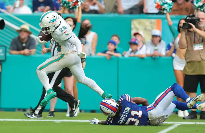 Nov 9, 2025; Miami Gardens, Florida, USA; Miami Dolphins running back De'Von Achane (28) runs for a touchdown against Buffalo Bills cornerback Maxwell Hairston (31) during the second half at Hard Rock Stadium. Mandatory Credit: Sam Navarro-Imagn Images