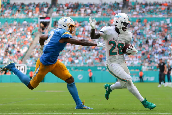 Oct 12, 2025; Miami Gardens, Florida, USA; Miami Dolphins running back De'Von Achane (28) carries the football for a touchdown against Los Angeles Chargers free safety Derwin James (3) during the fourth quarter at Hard Rock Stadium. Mandatory Credit: Sam Navarro-Imagn Images