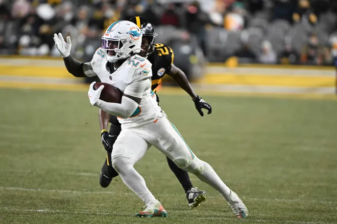 Dec 15, 2025; Pittsburgh, Pennsylvania, USA; Miami Dolphins running back De'Von Achane (28) runs past Pittsburgh Steelers cornerback Brandin Echols (26) during the second half at Acrisure Stadium. Mandatory Credit: Barry Reeger-Imagn Images