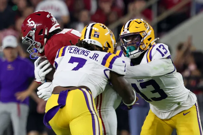 Nov 8, 2025; Tuscaloosa, Alabama, USA; Louisiana State Tigers linebacker Harold Perkins Jr. (7) and defensive back A.J. Haulcy (13) tackle Alabama Crimson Tide wide receiver Germie Bernard (5) during the first quarter of the game at Saban Field at Bryant-Denny Stadium. Mandatory Credit: David Leong-Imagn Images
